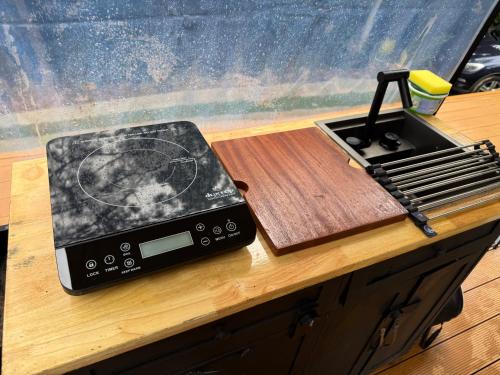 a device sitting on a table next to a cutting board at Safari Glamping By Ohana Green Home in Alto del Mamey