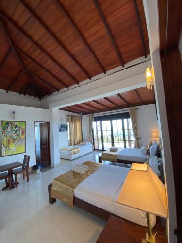 a large bedroom with a large bed and a couch at Kandy Highland Unique Hotel in Kandy