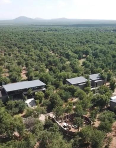 an aerial view of a building in the middle of a forest at Umoya Safari Lodge in Matlhagame