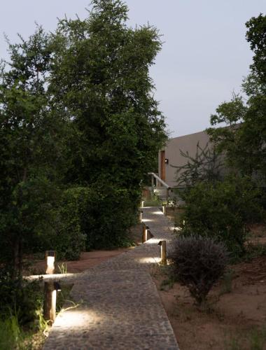 a stone path with lights on the side of a building at Umoya Safari Lodge in Matlhagame