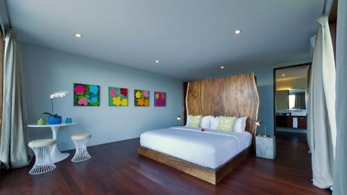 a bedroom with a bed with a wooden headboard at Malimbu Cliff Villa by Elite Havens in Senggigi