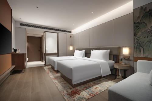 Un ou plusieurs lits dans un hébergement de l'établissement New Century Mansion Hotel Tongxiang Puyuan International Trade Center