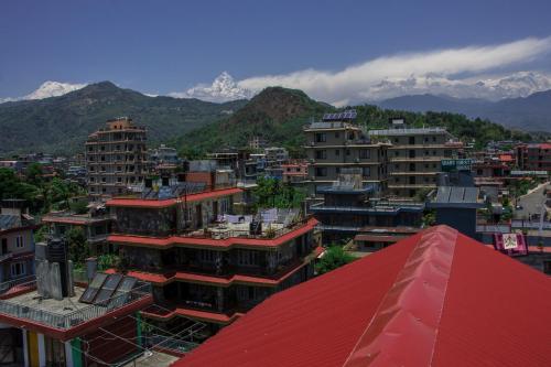 a city with buildings and mountains in the background at Peace Eye Guest House in Pokhara