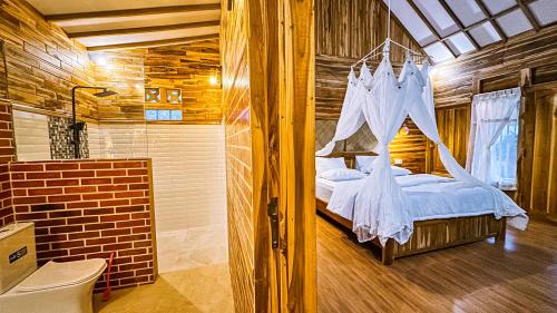 a bedroom with a bed with a net at Dunya Villa in Gili Air