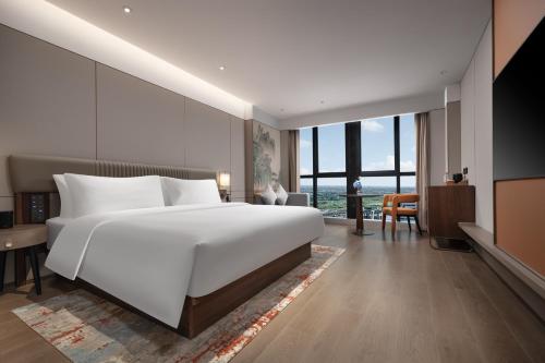 Un ou plusieurs lits dans un hébergement de l'établissement New Century Mansion Hotel Tongxiang Puyuan International Trade Center