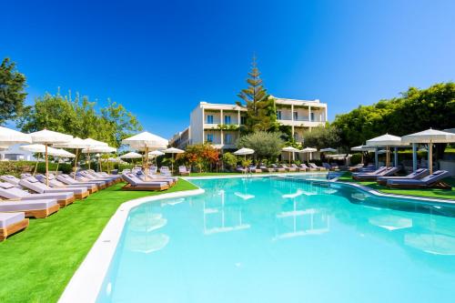 a swimming pool with lounge chairs and umbrellas at a resort at Dias by Azul Collection in Adelianos Kampos