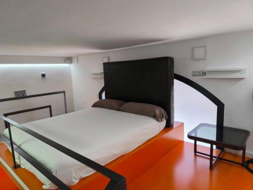 a bedroom with a black bed and a table at La casa del Mamut - Viladecans in Viladecáns