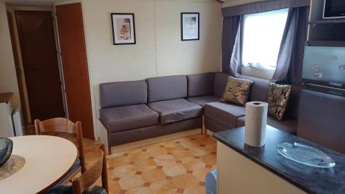 un salon avec un canapé et une table dans l'établissement Rio 2 mobile home 4, à Noyelles-sur-Mer