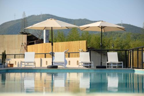 a swimming pool with chairs and umbrellas on a building at Dashuxia Hotel in Houhong