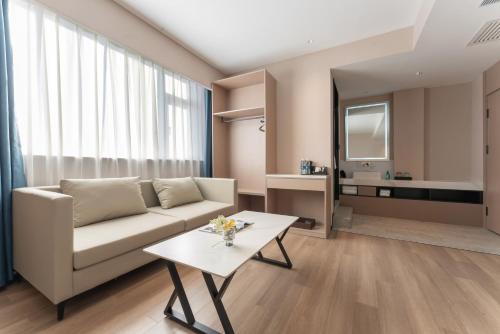 a living room with a couch and a table at 沃德德州汽车总站万达广场店 in Dezhou
