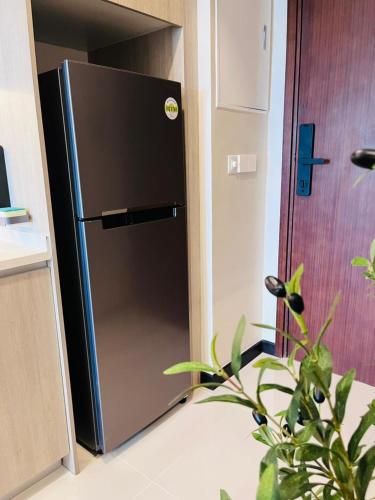 a black refrigerator in a kitchen with a plant at Colombo, Trizen Luxury Apartments, Sri Lanka in Colombo