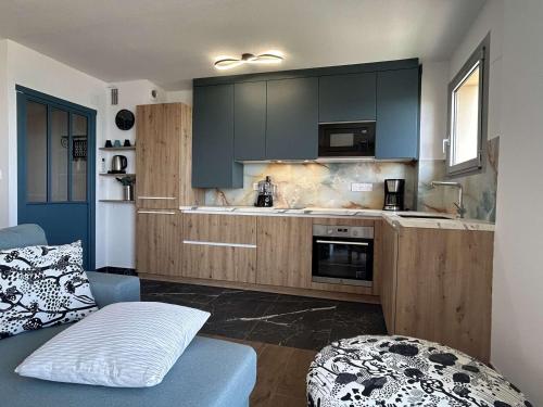 une cuisine avec des placards noirs et un canapé bleu dans l'établissement T3 moderne avec climatisation et parking, à 200m de la plage - FR-1-225C-177, à Banyuls-sur-Mer