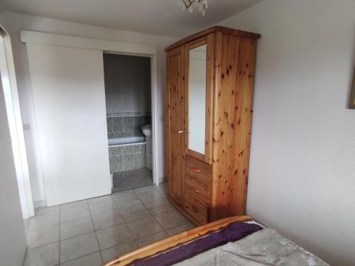 - une chambre avec une armoire en bois et une salle de bains dans l'établissement Charmant appartement 2 pièces avec loggia et parking à deux pas de la plage - FR-1-712-93, à Villers-sur-Mer
