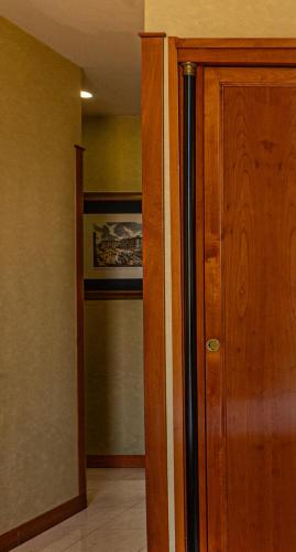 a hallway with a wooden door and a closet at Hotel Miami in Rome