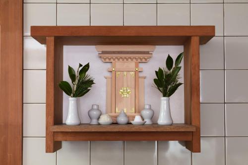 a shelf with vases and a door with plants on it at Villa璃都りーと Villa Retreat in Ibaraki
