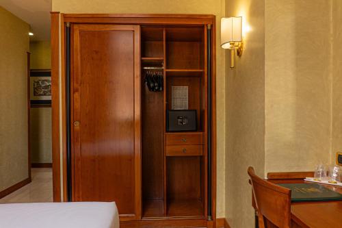 a room with a wooden cabinet next to a table at Hotel Miami in Rome