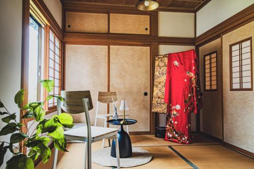 a living room with a chair and a table at 【佐渡/一棟貸切】オーシャンビュー古民家SeaSideStory椿 離れ in Sado