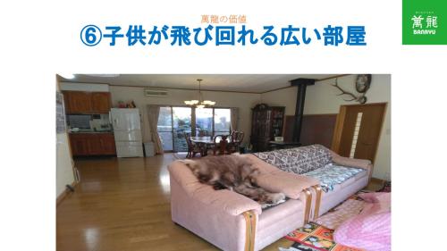 a dog laying on a couch in a living room at BANRYU 萬龍 バンリュウ in Iida