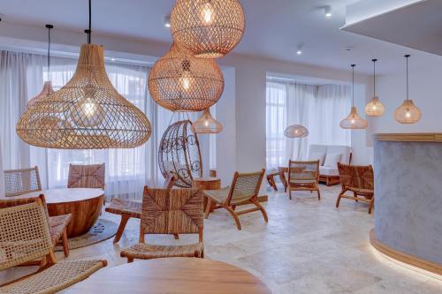 a room with chairs and tables and chandeliers at La Boheme - Adults Only in Obzor