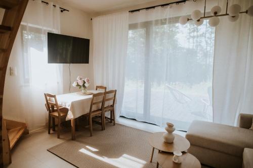 a living room with a table and a large window at Osada Zawadka in Zawadka
