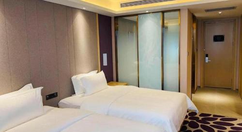 a hotel room with two beds and an elevator at Lavande Hotel Changchun Gaoxin Jilin University in Changchun