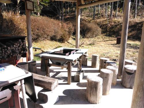 a picnic table and some logs and a grill at BANRYU 萬龍 バンリュウ in Iida