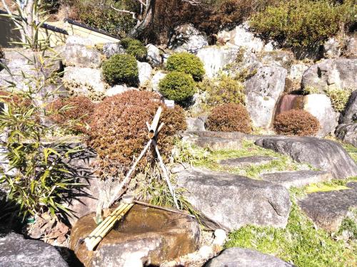 a garden with rocks and a wooden object in it at BANRYU 萬龍 バンリュウ in Iida