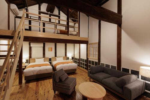 a bedroom with two beds and a loft bed at Nipponia Hotel 伊勢河崎 商人町 in Ise