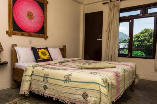 a bedroom with a bed with a large window at Peace Eye Guest House in Pokhara
