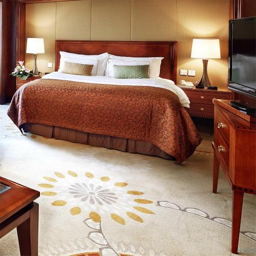a bedroom with a large bed and a television at Lakeview Xuanwu Hotel in Nanjing