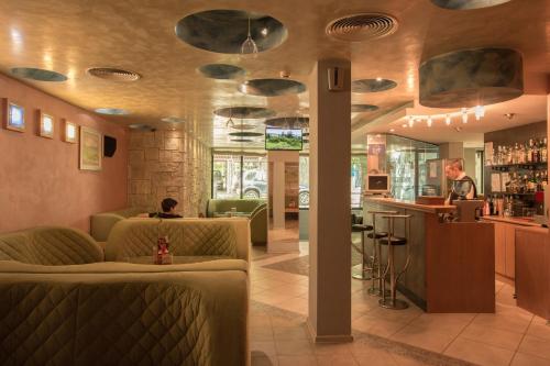 un bar en un restaurante con gente sentada en un mostrador en Hotel Divesta - self check in, en Varna