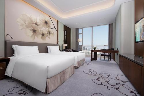 a hotel room with a large bed and a desk at Kempinski Hotel Changsha in Changsha
