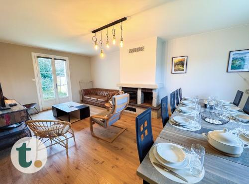 une salle à manger avec une table et un salon dans l'établissement Tranquiloue - Grande maison spacieuse - PuyduFou, aux Herbiers
