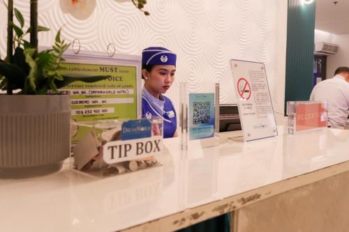 a man in a hat sitting at a try box counter at Hotel Dreamworld North Edsa in Manila