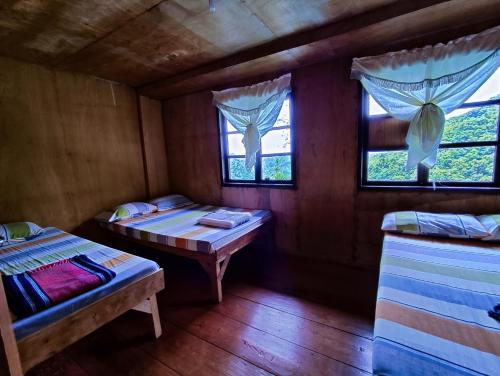 a room with two beds and two windows at BATAD Simons Viewpoint Inn and Pizza Restaurant in Banaue