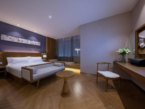 a hotel room with a bed and a couch and a table at Crystal Orange Hotel Tianjin Jinghai Dongfanghong Road in Tianjin