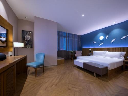 Un pat sau paturi într-o cameră la Crystal Orange Hotel Tianjin Jinghai Dongfanghong Road