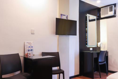 a room with a table and chairs and a mirror at Hotel Dreamworld North Edsa in Manila
