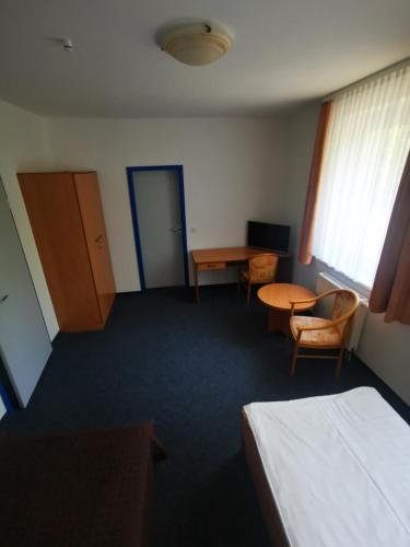 a room with a bed and a table and a desk at Pilotenunterkunft Fliegerhorst in Strausberg