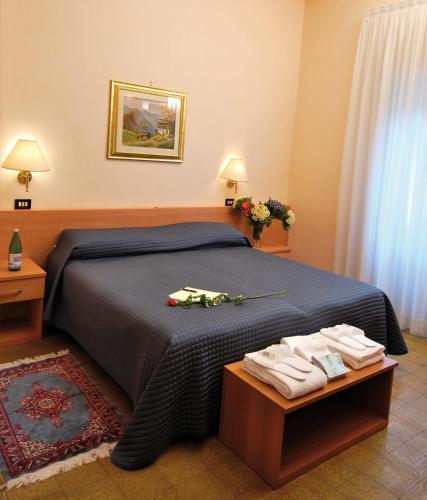a bedroom with a bed and a table with towels on it at Hotel Delle Ortensie in Fiuggi
