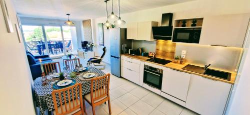 une cuisine avec une table et une salle à manger dans l'établissement THAU-INDIGO, Appt Neuf, Standing, Prox Plages, Terrasse, Parking, Climatisé, à Sète