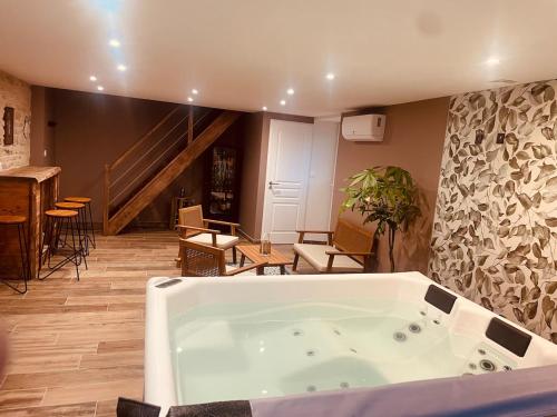 Una bañera en una sala de estar con escalera. en La Chance Spa cottage 6 personnes, en Orges