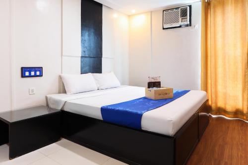 a small room with a bed with a box on it at Hotel Dreamworld North Edsa in Manila