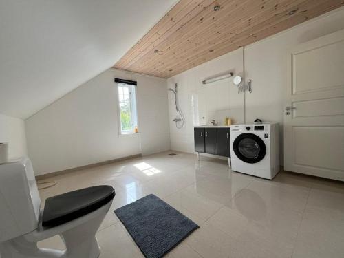 a large white room with a washing machine in it at Hvaler Apartment - Skjærhalden, Storesand in Hvaler