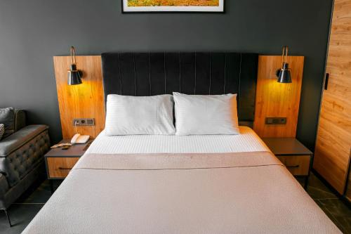 a bedroom with a large bed and a couch at Burç Otel in Pelitli