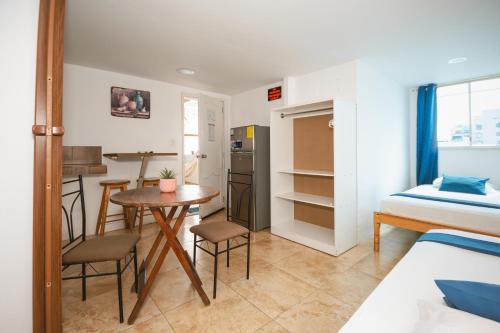 a small room with a bed and a table and chairs at Hotel Casa Latina in Manta