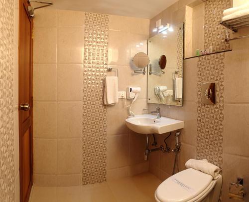 a bathroom with a toilet and a sink at Vishnu Inn in Guruvāyūr