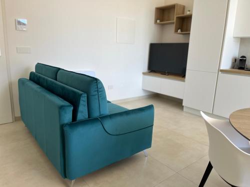 a blue couch in a living room with a tv at Valesium Home in Lecce