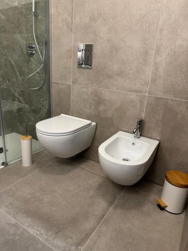 a bathroom with a toilet and a sink and a shower at Domus Aura Apartments in SantʼAntìoco