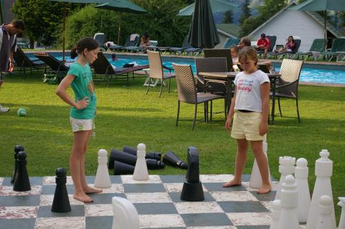 Champagne Castle Hotel في Champagne Valley: طفلين يلعبان الشطرنج على لوح شطرنج عملاق